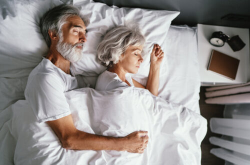 Älteres Ehepaar, das zusammen im Bett schläft.