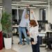 Mitarbeitende machen Gymnastik im Büro